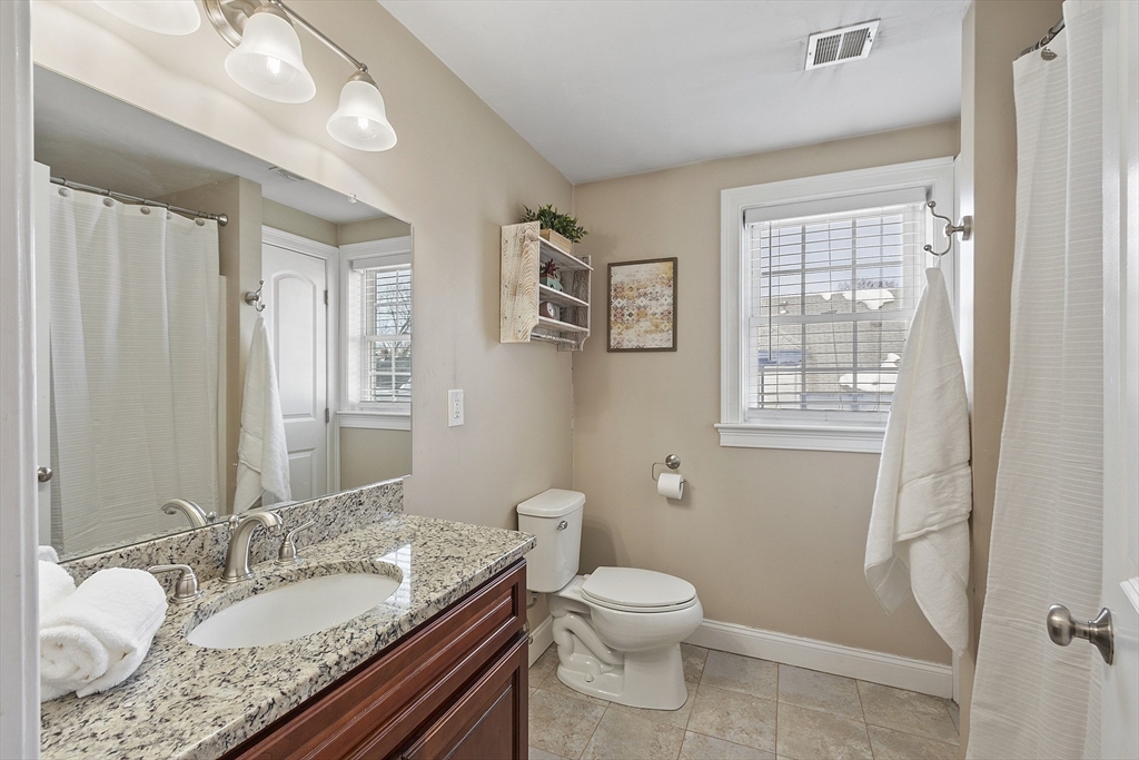 103 Reed Street Rockland, MA 02370 - Photo 25 of 33 a bathroom with a granite countertop sink a mirror and a toilet