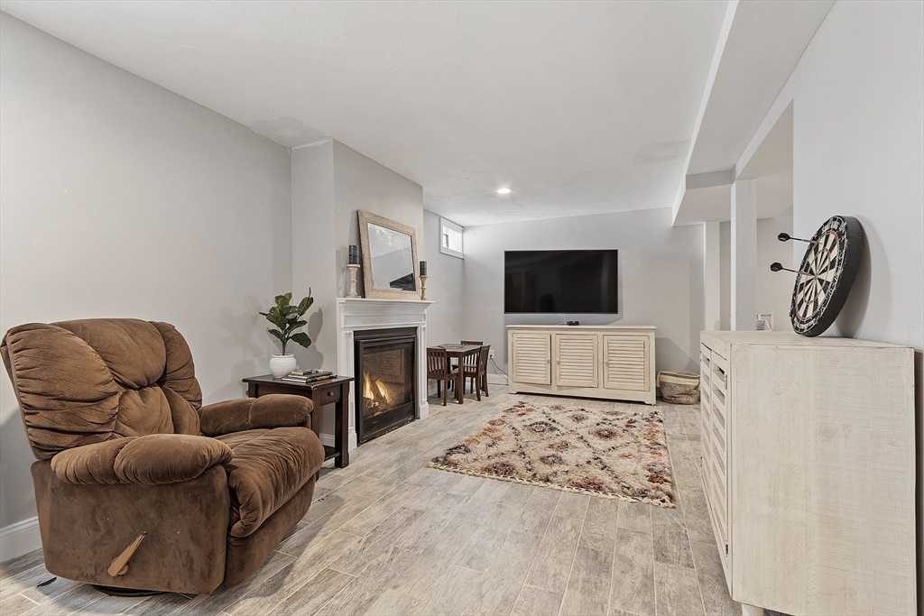 103 Reed Street Rockland, MA 02370 - Photo 27 of 33 a living room with furniture a flat screen tv and a fireplace