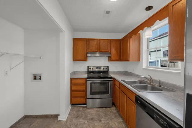 a kitchen with a stove sink and cabinets