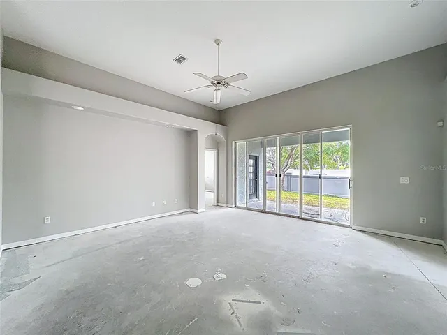 a view of an empty room with a chandelier fan