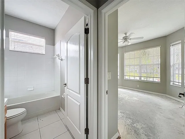 an empty room with windows and cabinet