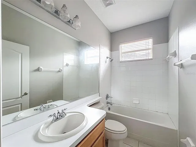a view of a livingroom with a chandelier fan and windows