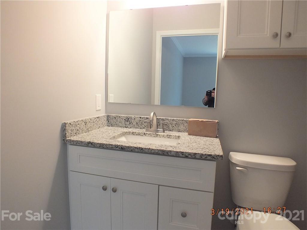 2302 Douglas Road Lancaster, SC 29720 - Photo 14 of 17 a bathroom with a granite countertop toilet sink and mirror