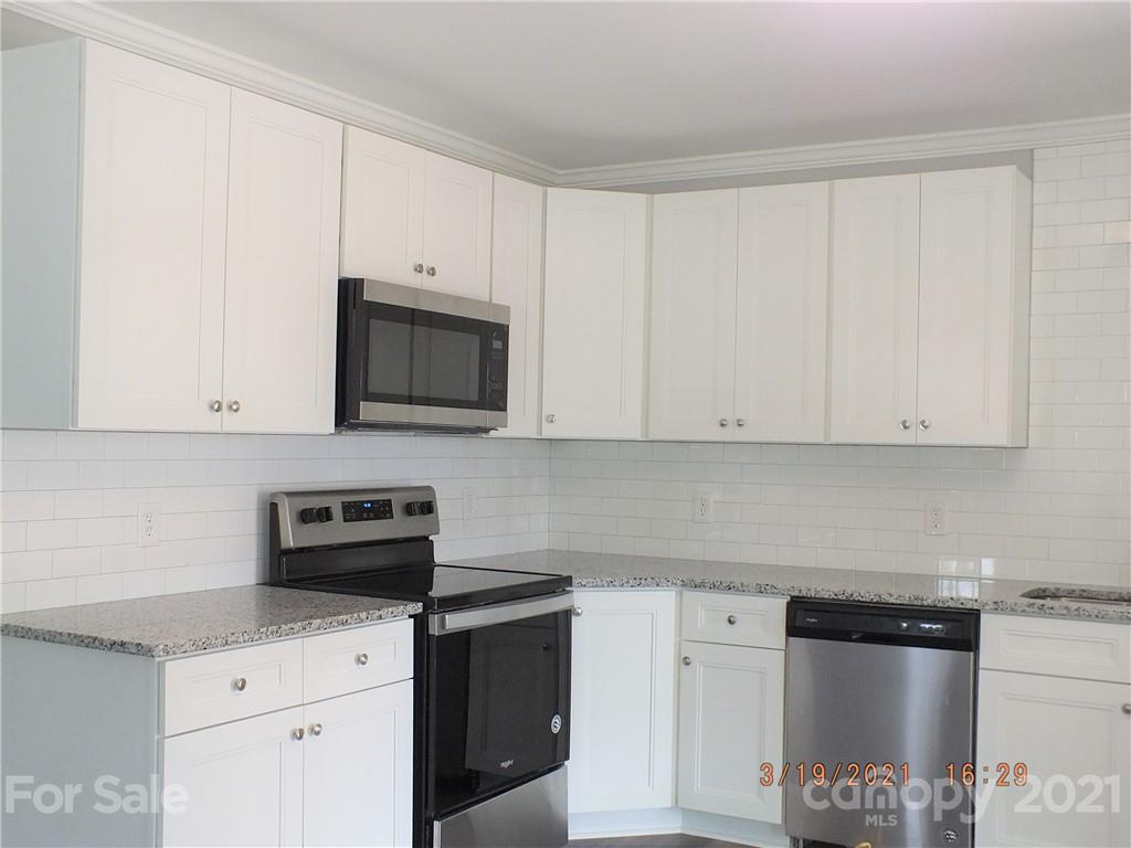 2302 Douglas Road Lancaster, SC 29720 - Photo 4 of 17 a kitchen with granite countertop white cabinets and stainless steel appliances
