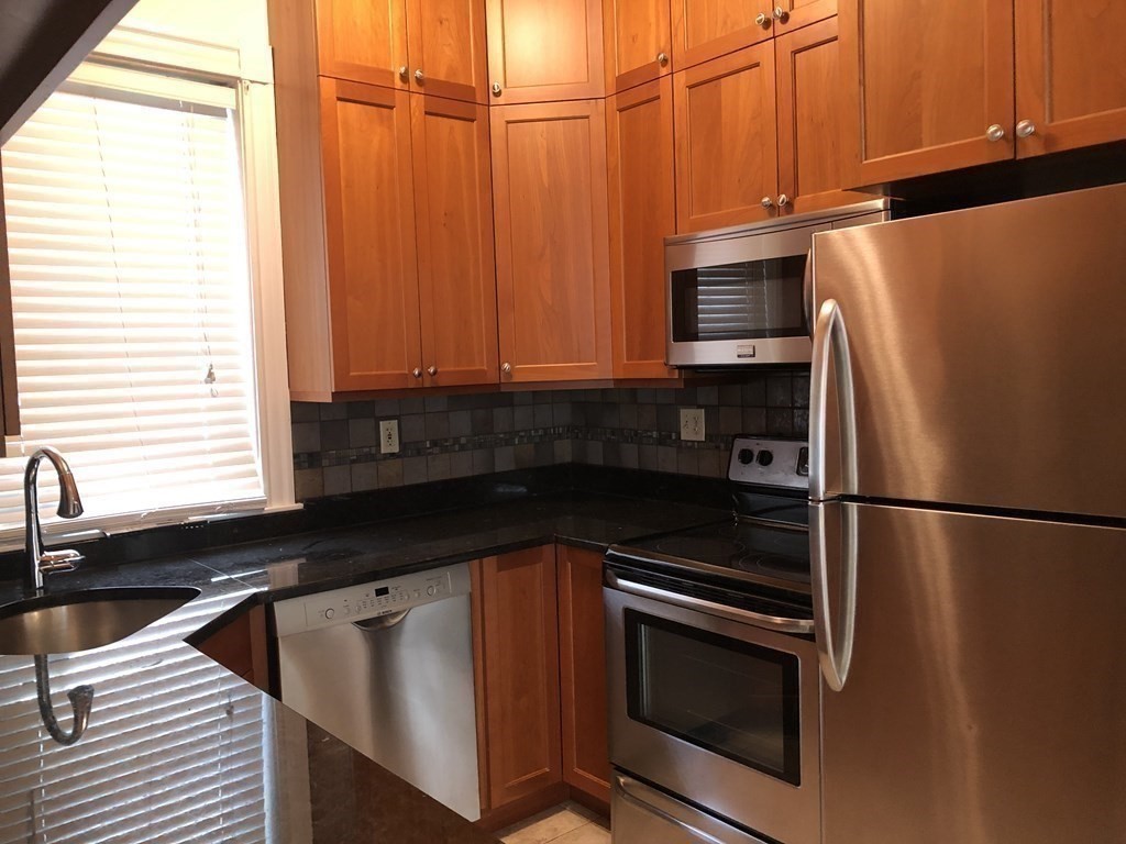 96 St Paul Street, Unit 2 Brookline, MA 02446 - Photo 7 of 14 a kitchen with stainless steel appliances a refrigerator sink and cabinets