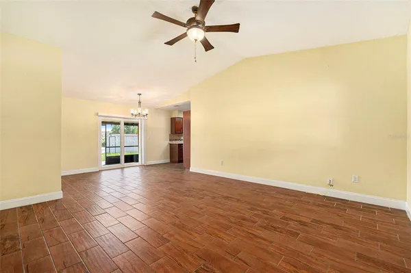 a view of a room with wooden floor and a ceiling fan