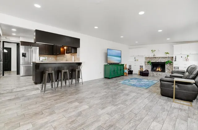 a living room with furniture a fireplace and kitchen view