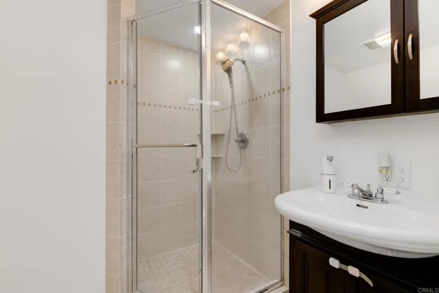 a bathroom with a sink a mirror a vanity and shower