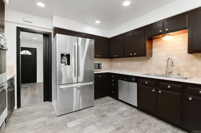 a kitchen with stainless steel appliances granite countertop a refrigerator and a sink