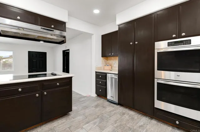a kitchen with stainless steel appliances kitchen island granite countertop a stove and a refrigerator