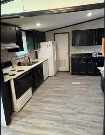 a kitchen with stainless steel appliances a stove a sink and a refrigerator