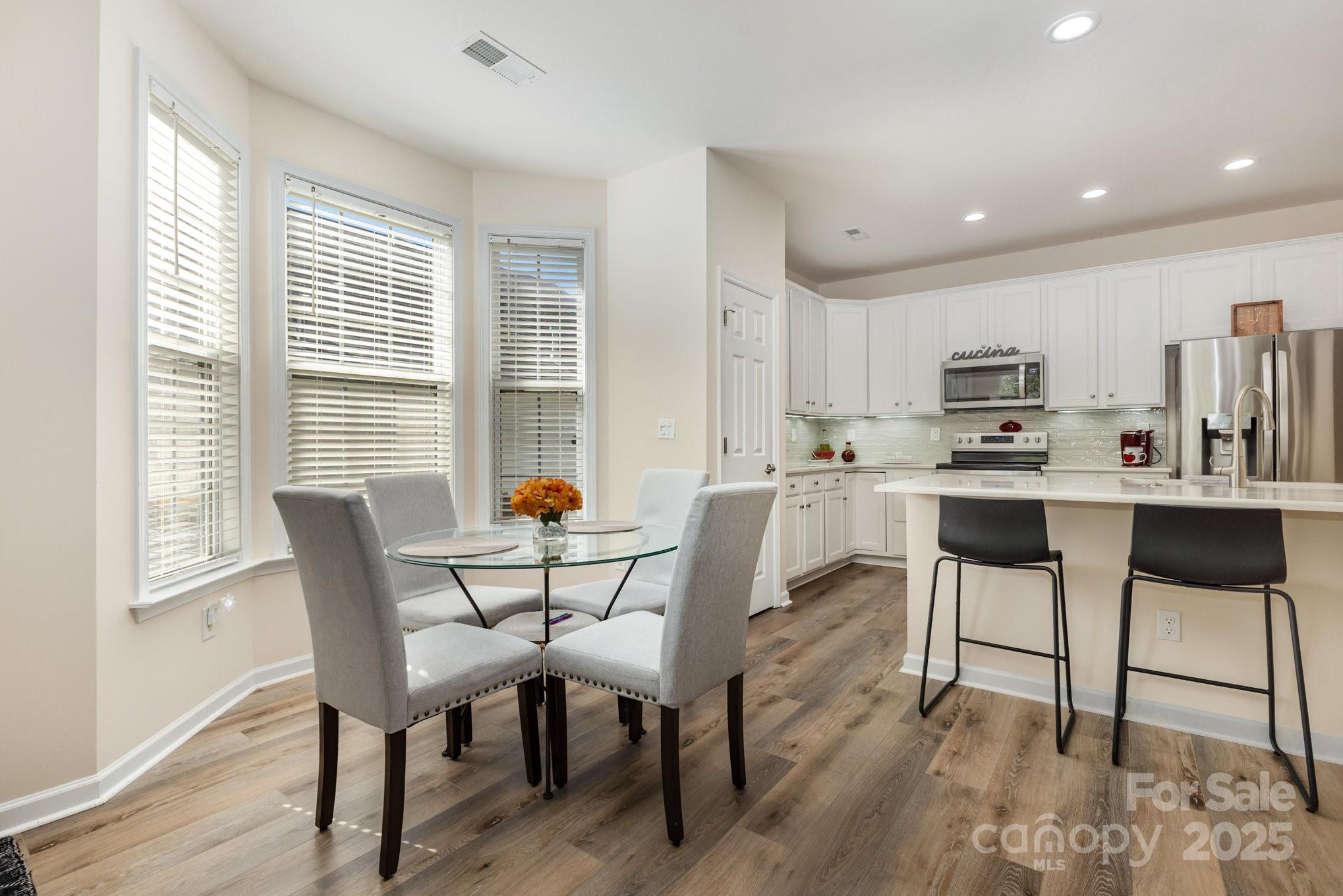 881 Platinum Drive Fort Mill, SC 29708 - Photo 12 of 35 a kitchen with stainless steel appliances kitchen island granite countertop a dining table chairs and granite counter tops