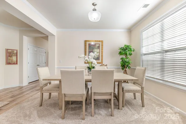 a dining room with furniture potted plants and wooden floor