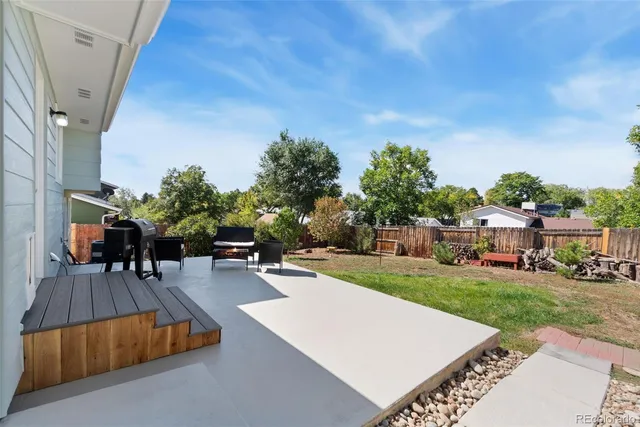 a view of a house with backyard and sitting area