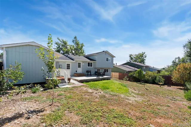 an aerial view of residential houses with outdoor space and trees