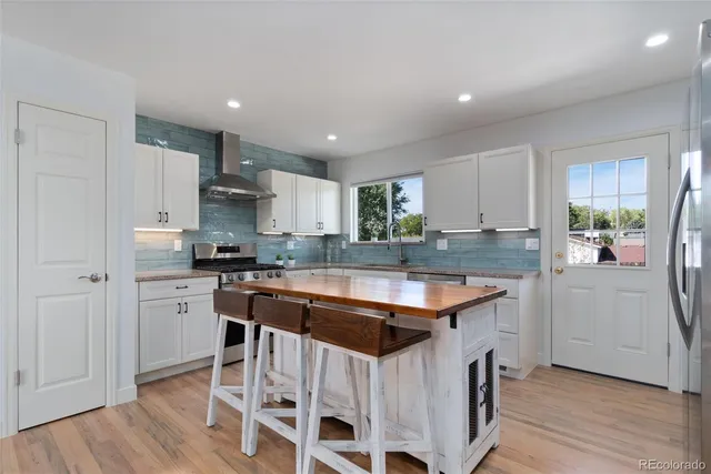 a kitchen with stainless steel appliances granite countertop refrigerator stove top oven and sink