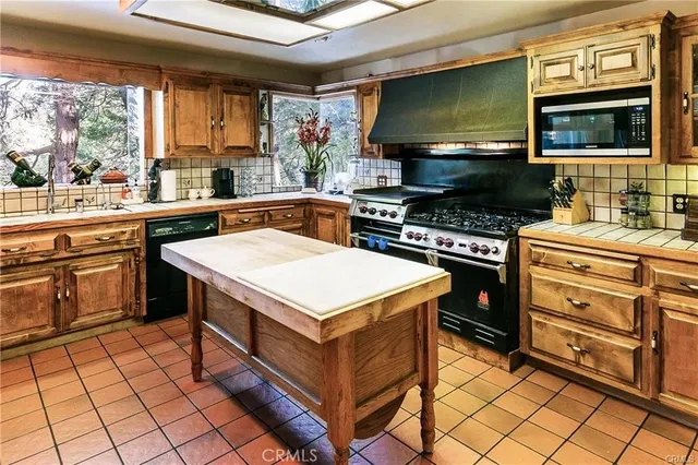 a kitchen with stainless steel appliances a stove sink and microwave