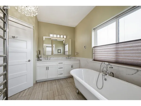 a bathroom with a bathtub a sink a mirror and a shower