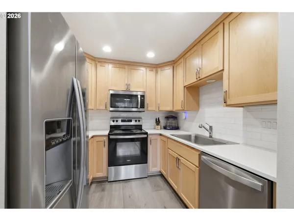 a kitchen with granite countertop white cabinets and stainless steel appliances