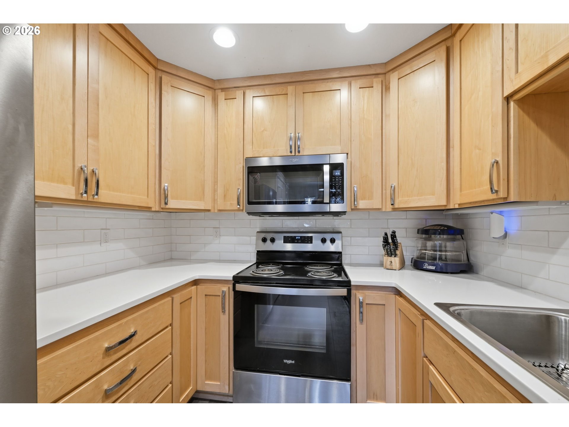 1308 East Main Street Cottage Grove, OR 97424 - Photo 31 of 48 a kitchen with granite countertop white cabinets and stainless steel appliances
