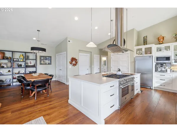 a kitchen with a stove and wooden floor