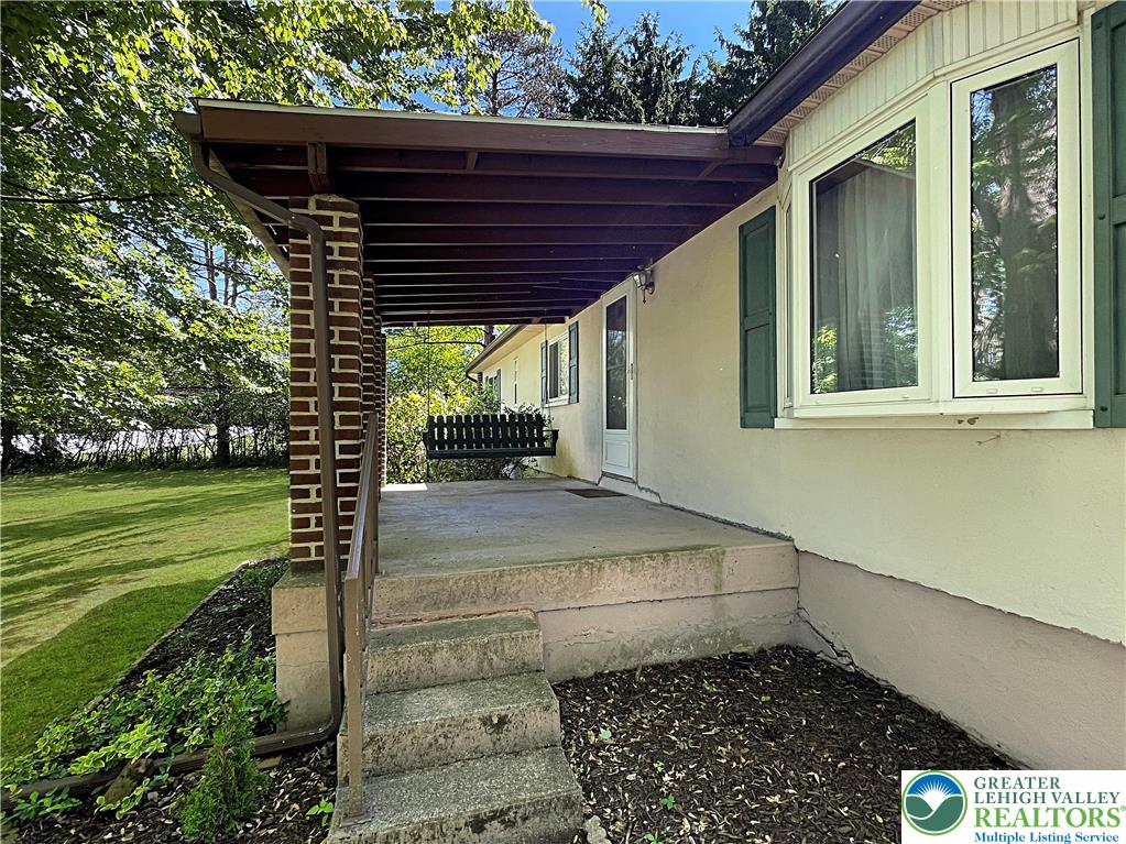 3406 Church Road Easton, PA 18045 - Photo 33 of 39 A welcoming covered porch with a swing offers a serene outdoor retreat.