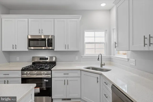 a kitchen with white cabinets and a stove top oven