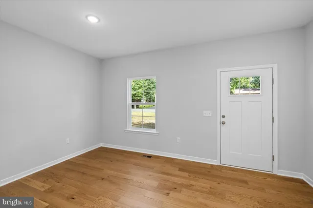a view of a room with wooden floor and white doors