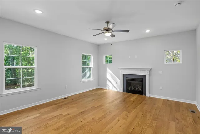 a view of an empty room with a window and fireplace