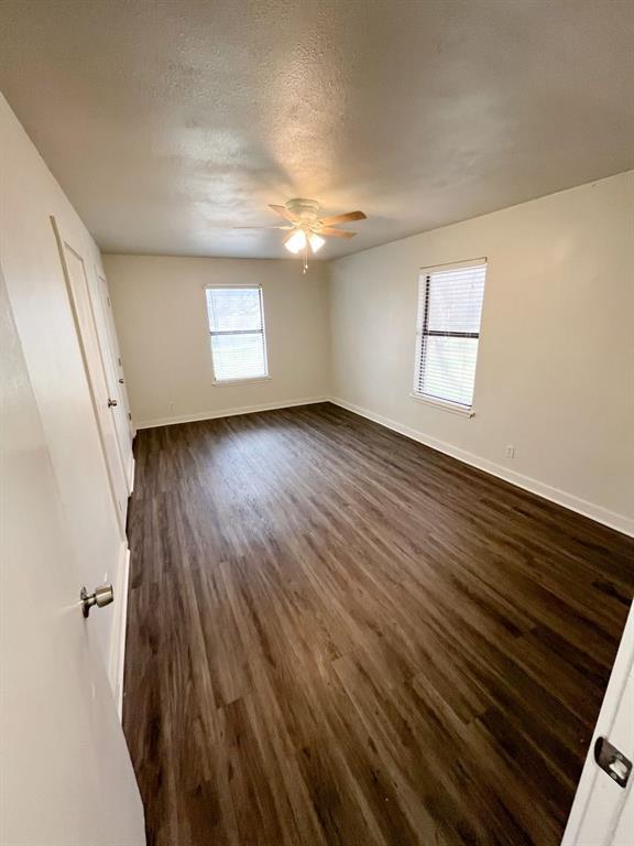 206 East 3rd Street Tolar, TX 76476 - Photo 14 of 21 an empty room with wooden floor and windows