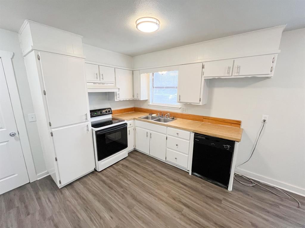 206 East 3rd Street Tolar, TX 76476 - Photo 8 of 21 a kitchen with white cabinets and white appliances
