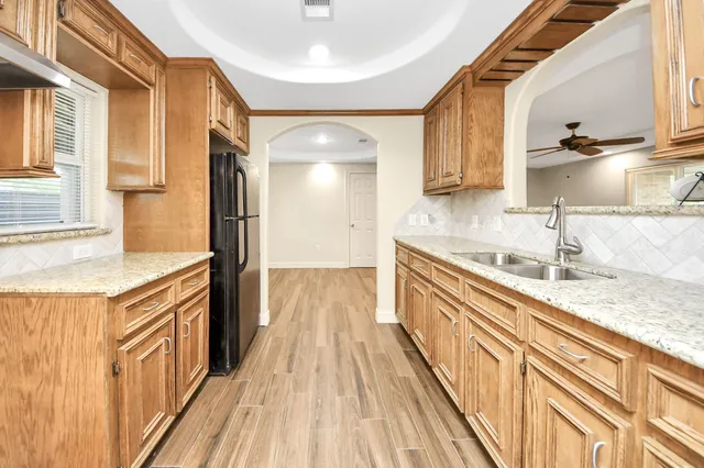 a kitchen with granite countertop a sink and a refrigerator