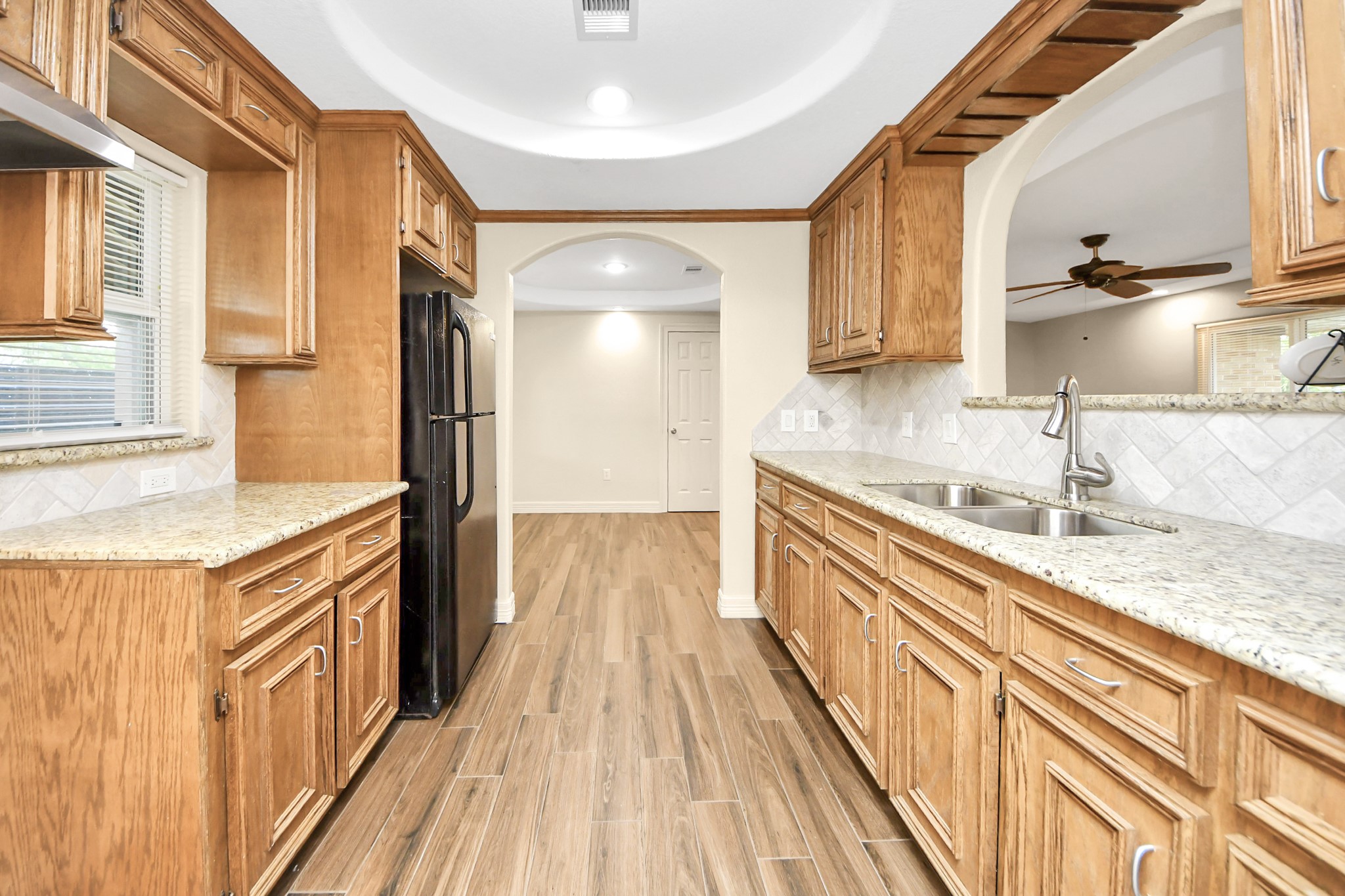8925 Homewood Lane Houston, TX 77078 - Photo 11 of 28 a kitchen with granite countertop a sink and a refrigerator