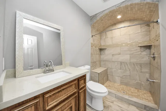 a bathroom with a sink a toilet and shower