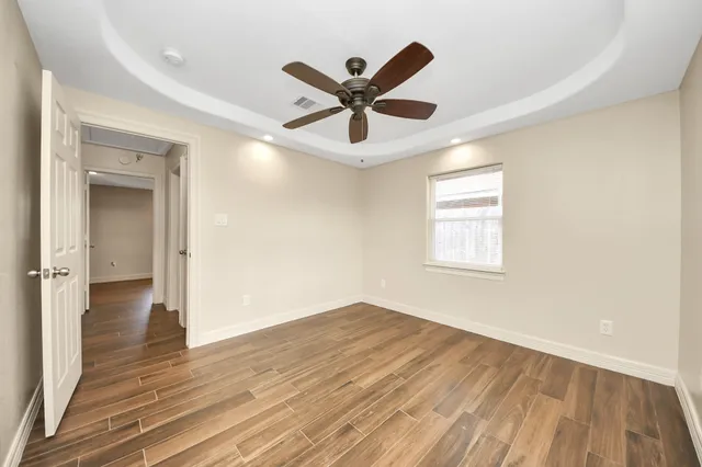 a view of a room with wooden floor and ceiling fan