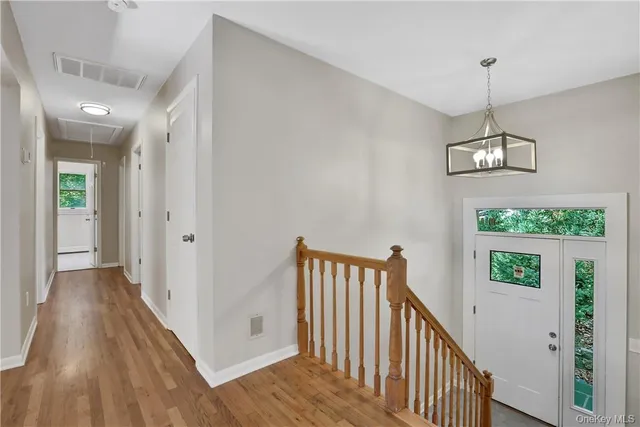 a view of a hallway with wooden floor and stairs