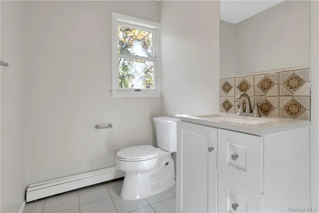 a bathroom with a granite countertop toilet and a sink
