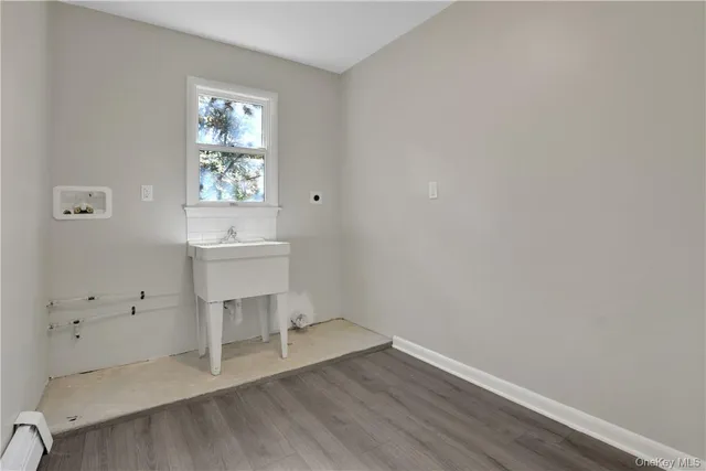 an empty room with a window and wooden floor