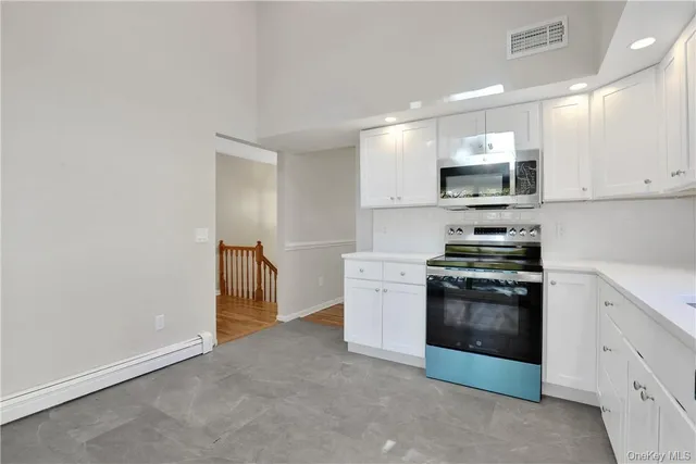 a kitchen with stainless steel appliances a stove microwave and sink