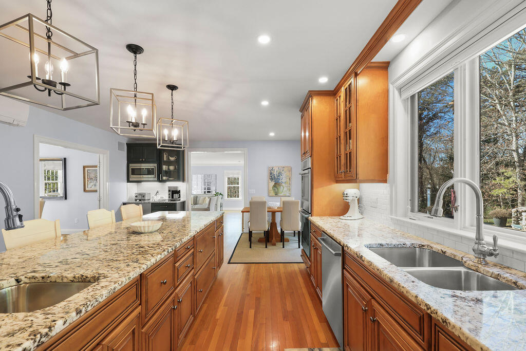 5 Fairfield Drive East Sandwich, MA 02537 - Photo 20 of 72 a large kitchen with granite countertop a large counter space wooden floor stainless steel appliances and living room view