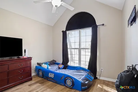 a living room with a bed and a flat screen tv