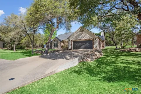 a front view of a house with a yard and tree