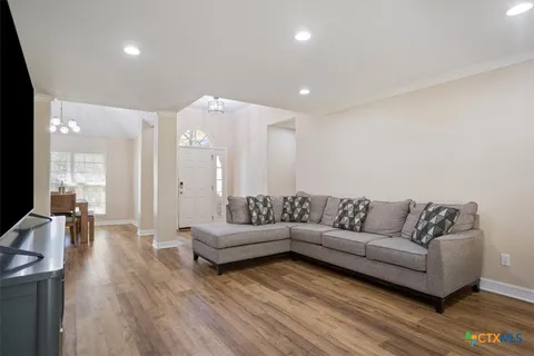 a living room with furniture and a wooden floor