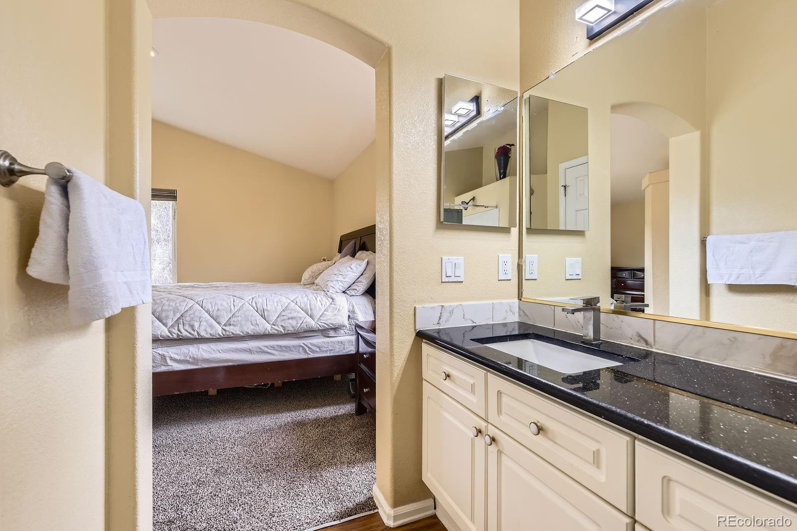 5329 Morning Glory Place Highlands Ranch, CO 80130 - Photo 17 of 28 a bedroom with a bed and a mirror