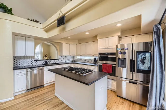 a kitchen with stainless steel appliances granite countertop a sink stove and refrigerator