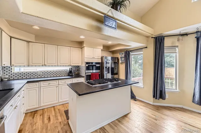a kitchen with stainless steel appliances granite countertop a sink stove and a refrigerator