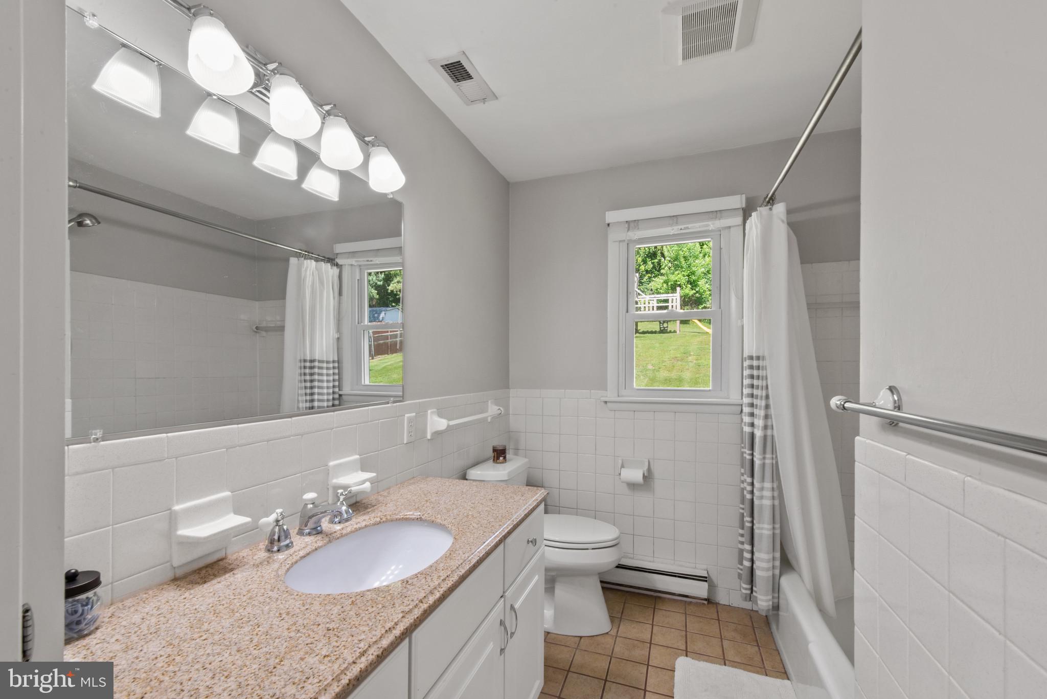 3242 Lineboro Road Manchester, MD 21102 - Photo 22 of 30 a bathroom with a granite countertop sink mirror vanity and a toilet