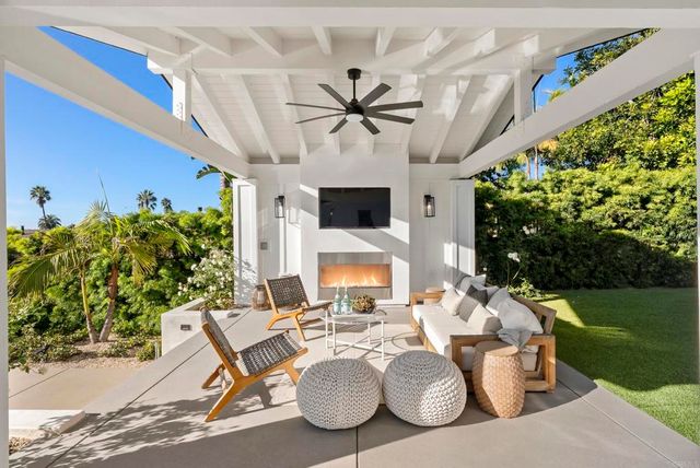 a living room with patio furniture and a chandelier