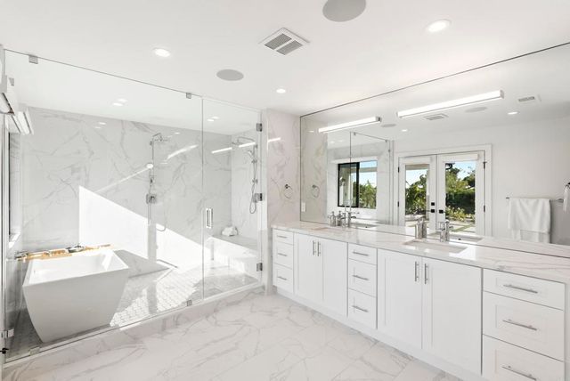 a bathroom with a tub a sink shower and mirror