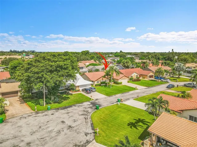 an aerial view of residential houses with outdoor space and trees